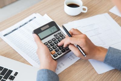 Person using a calculator to work out home much income tax they should pay
