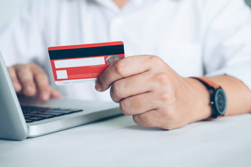 Man using credit card calculator to work out how to pay outstanding debt