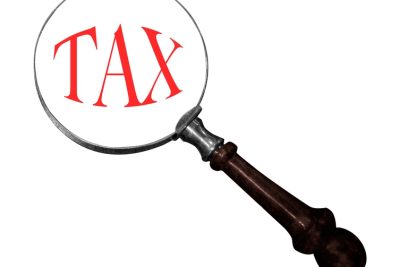 magnifying glass helping check tax minimum wage